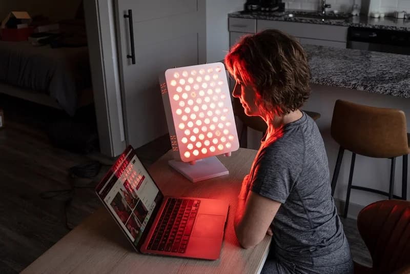 Woman using a RedLife Pro 100 panel at a home workspace